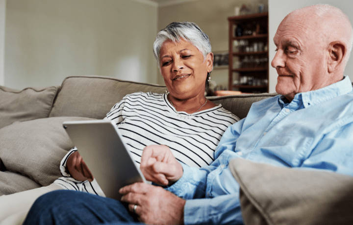 two old people looking at an ipad.
