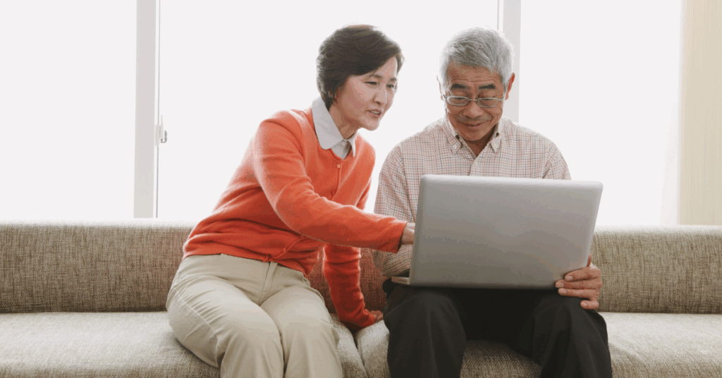 a senior couple looking something at a computer
