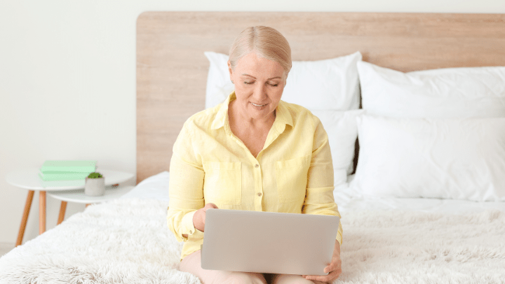 a senior lady reading in her laptop